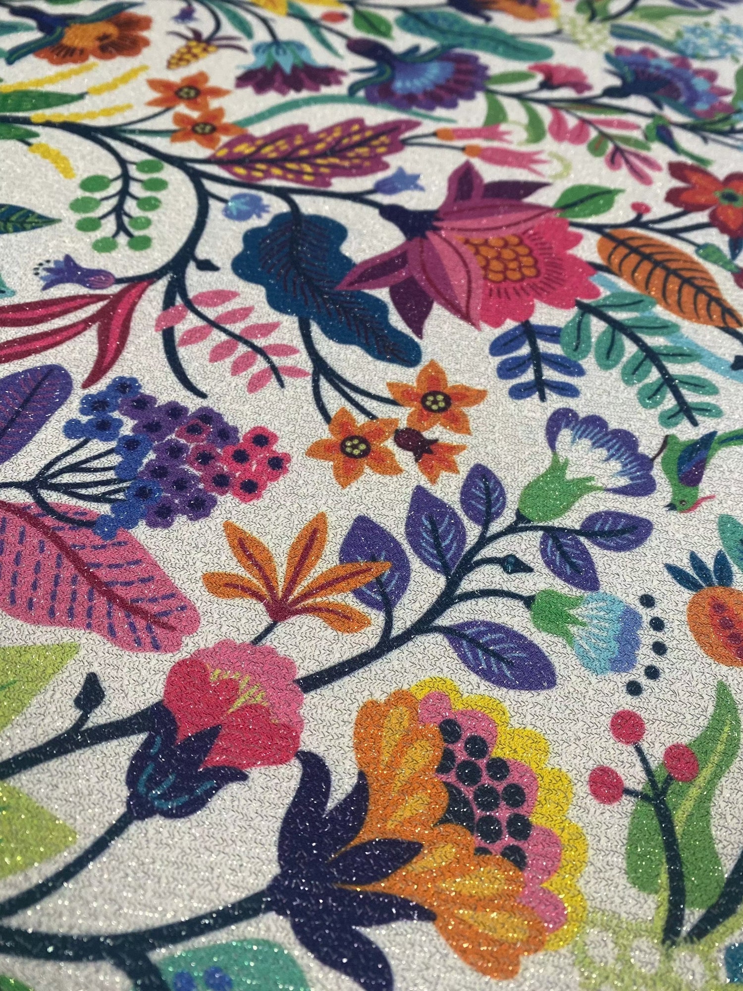 Colorful metallic floral and bird pattern on shimmering gold lurex fabric with 4-way stretch and glittery texture