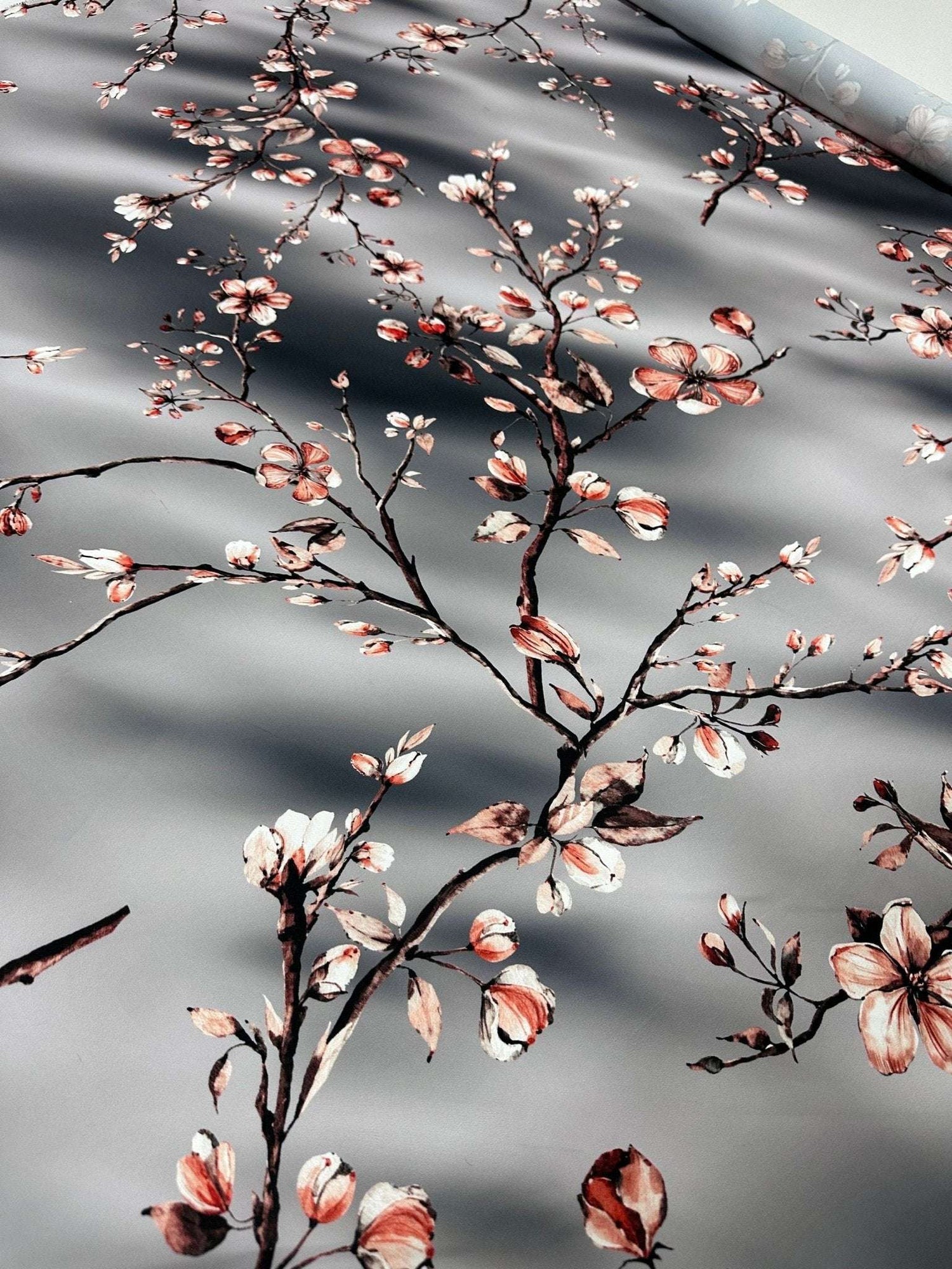 Gray almond blossom luxury fabric with elegant floral pattern on smooth gray background