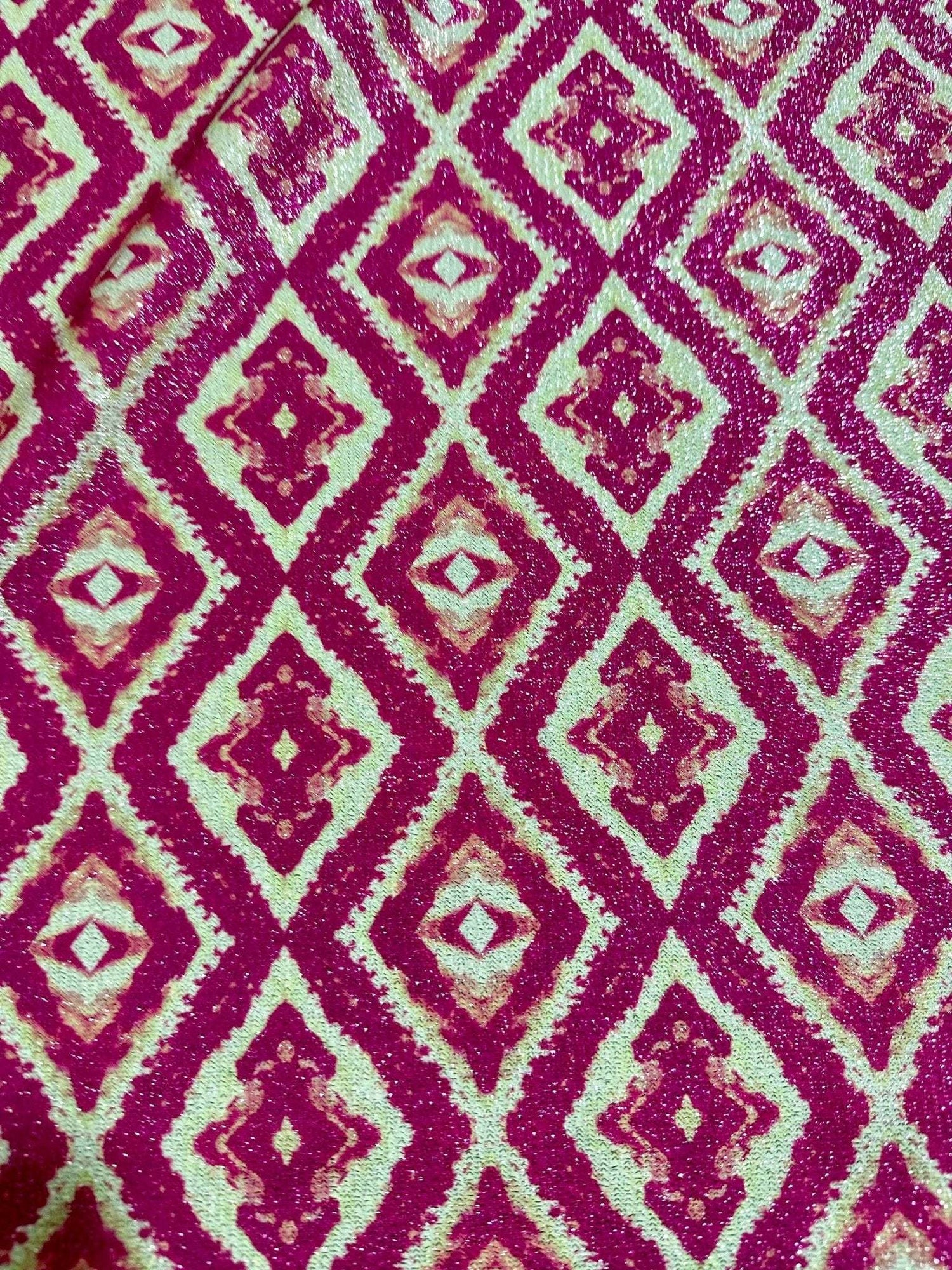 Close-up of Aztec Lurex Knit Fabric with pink and gold shimmering diamond pattern and 4-way stretch texture