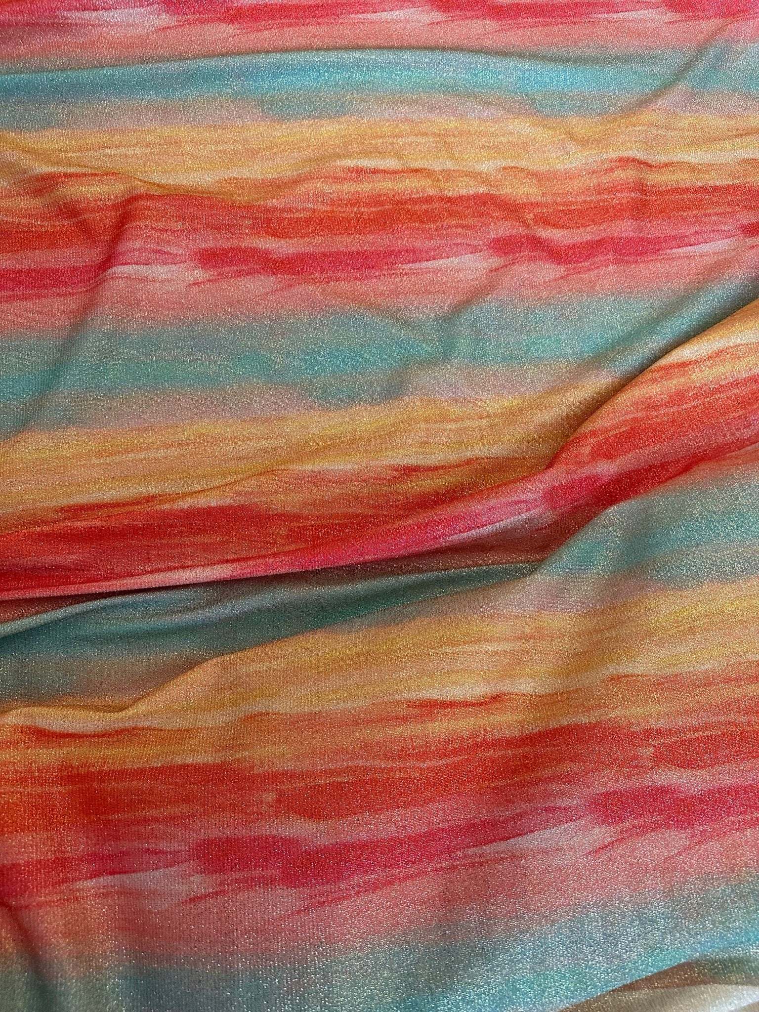 Batik Lurex two-way stretch spandex fabric with glitter tie-dye pattern in red, orange, yellow, and blue tones