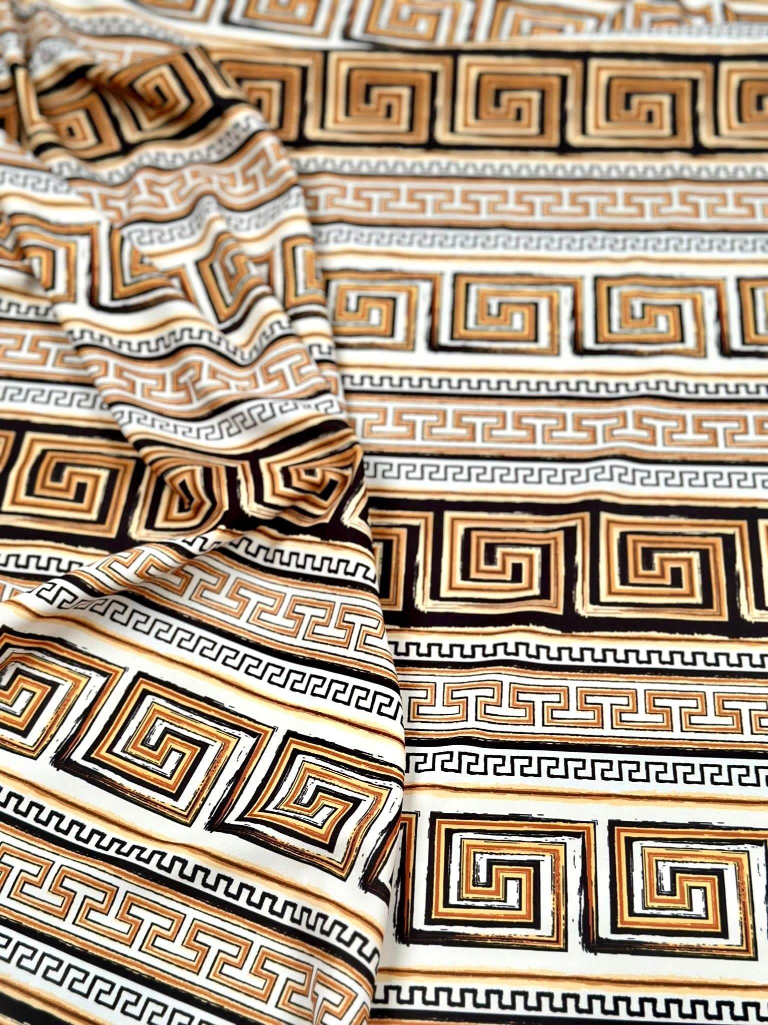 Beige brown silky crepe fabric with geometric Greek key pattern and smooth drape