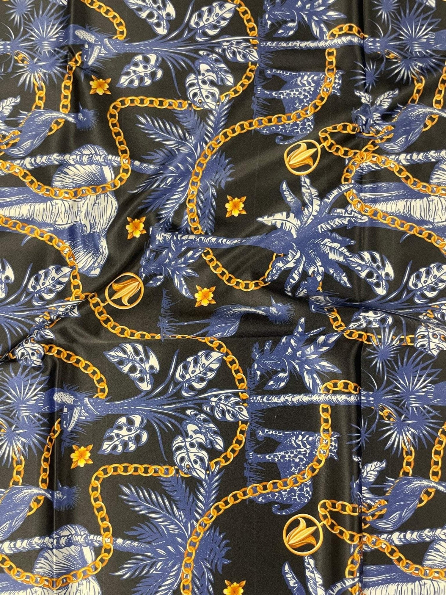 Black and blue tropical fabric with gold chain pattern and leafy design