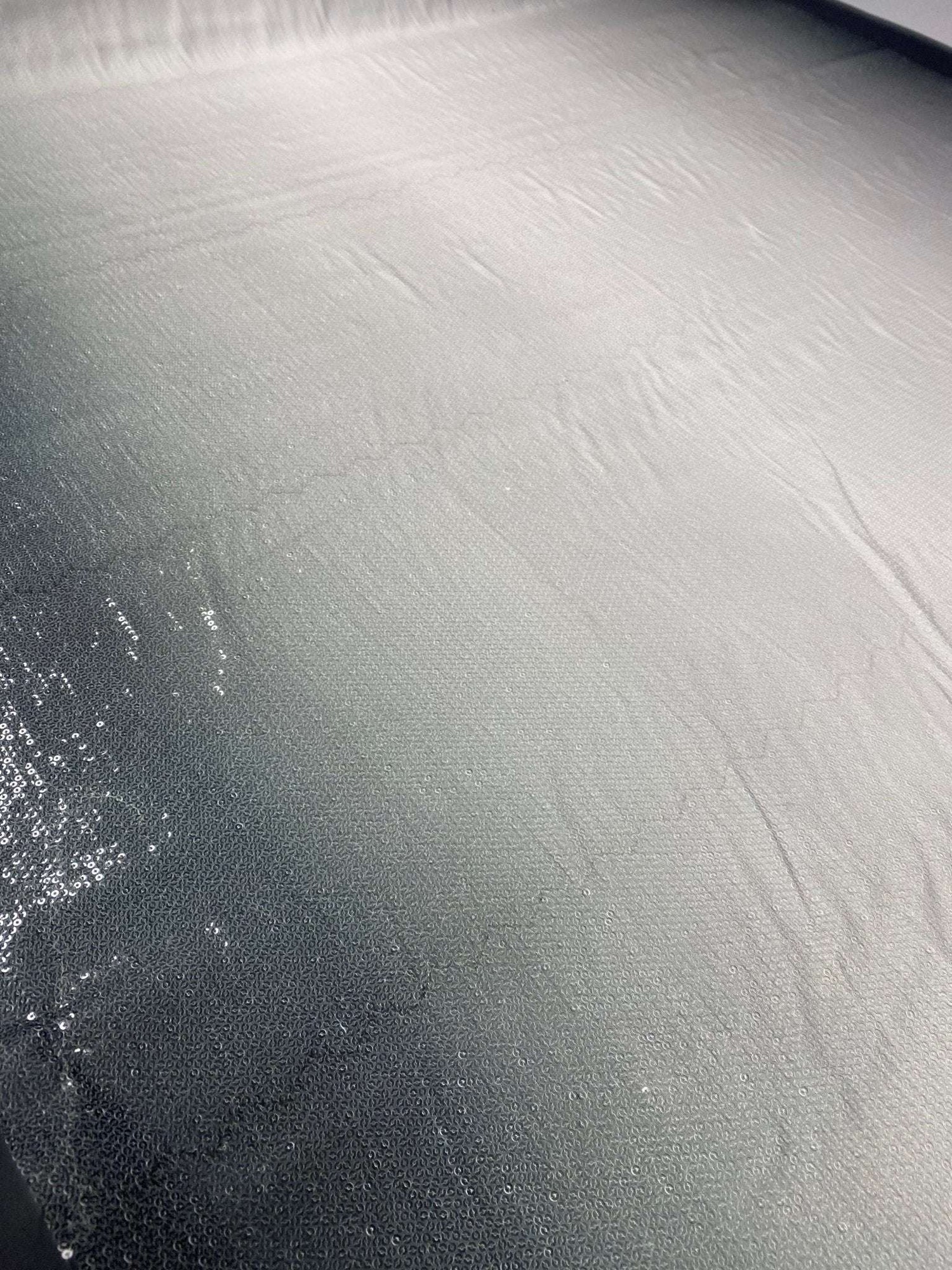 Black to white ombre sequin fabric with smooth gradient and subtle sparkle for fashion design