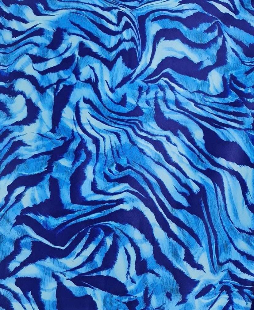 Blue zebra print fabric with vibrant blue and black striped pattern, ideal for sewing projects and home decor.