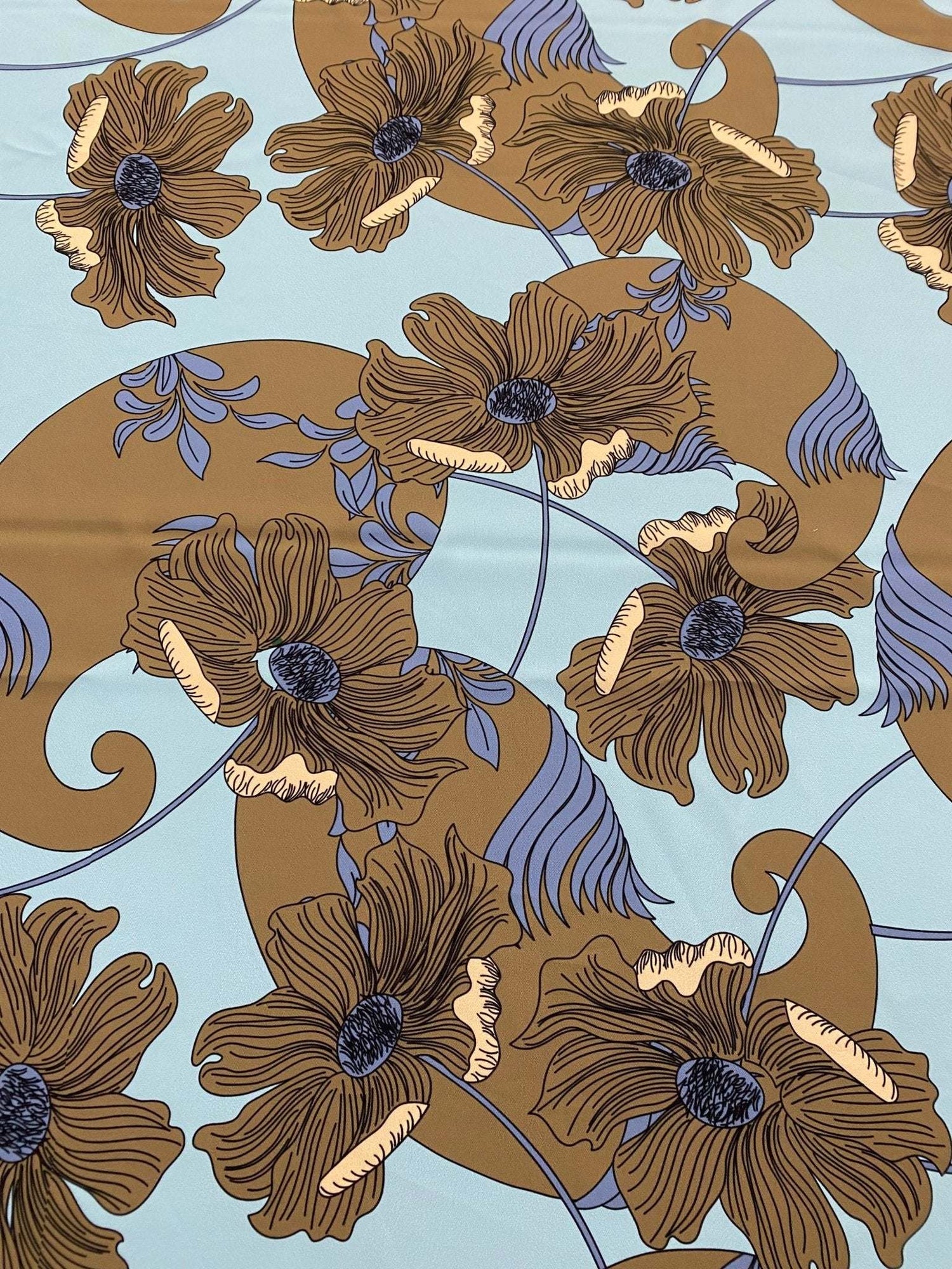 Brown floral print fabric on light blue background with purple and tan accents