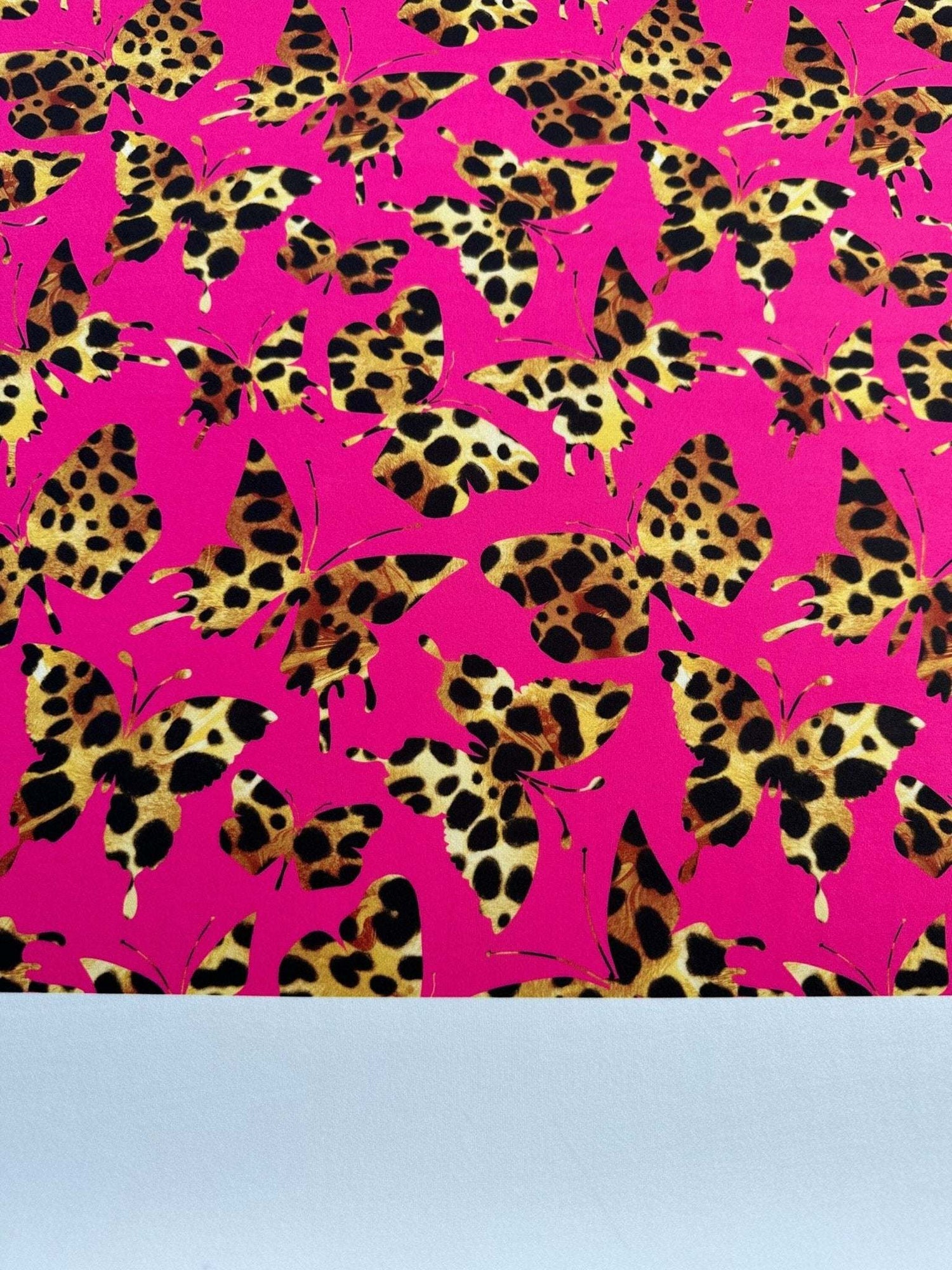 Hot pink fabric with leopard print butterfly pattern