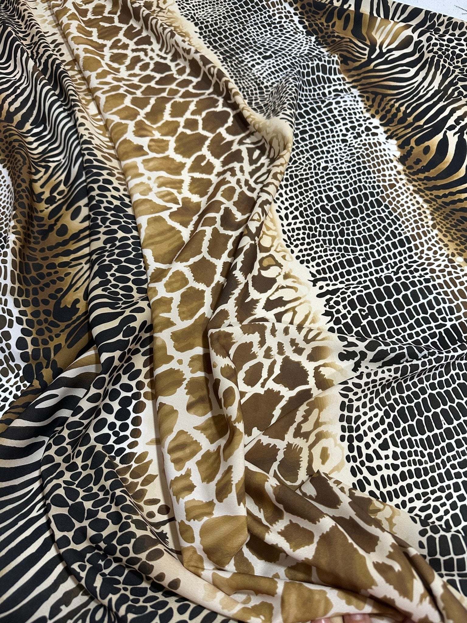 Exotic animal print fabric with giraffe, zebra, and leopard patterns in neutral tones