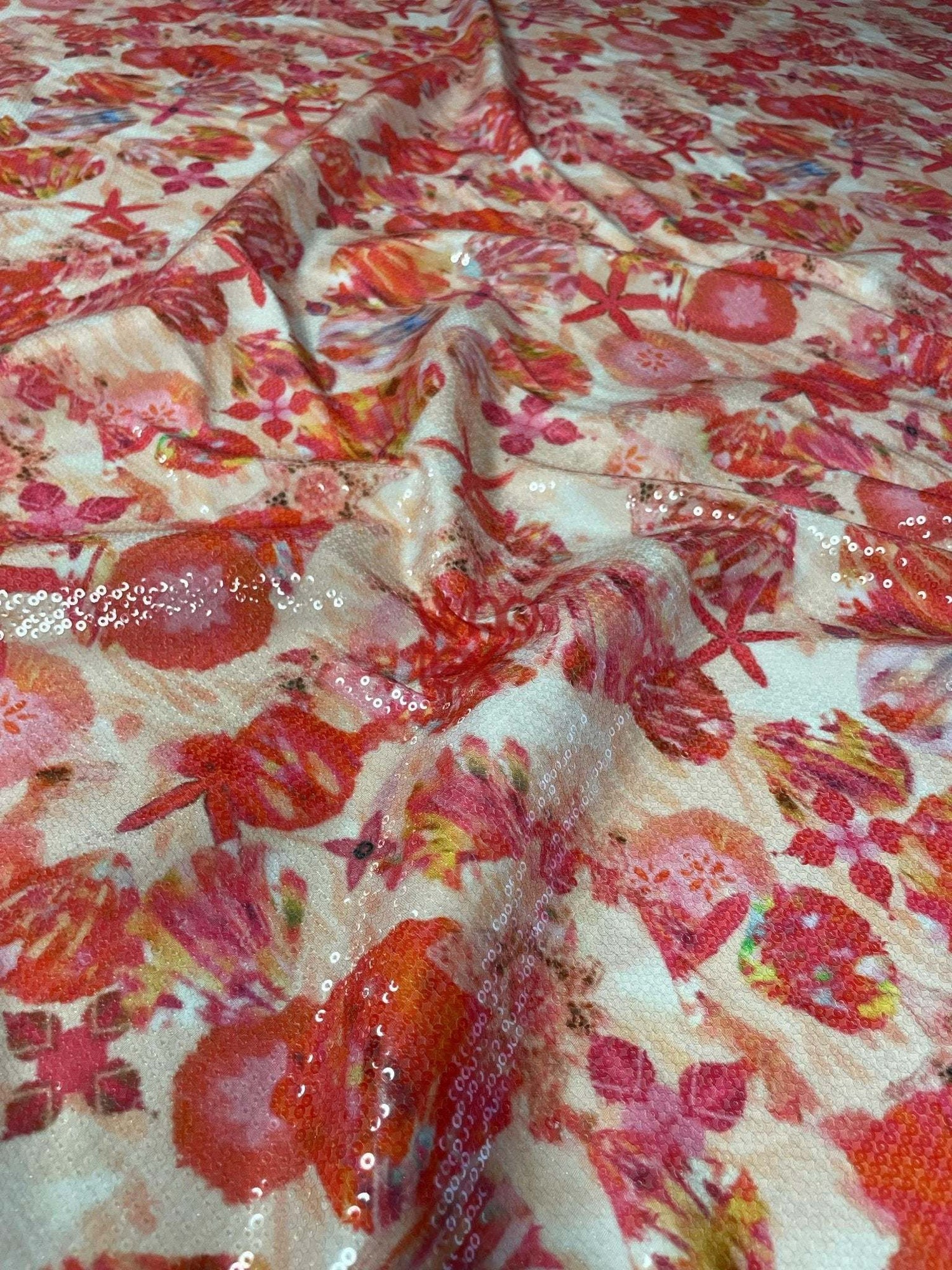 Floral sequin fabric with red and pink starfish design and 2-way stretch for fashion wear