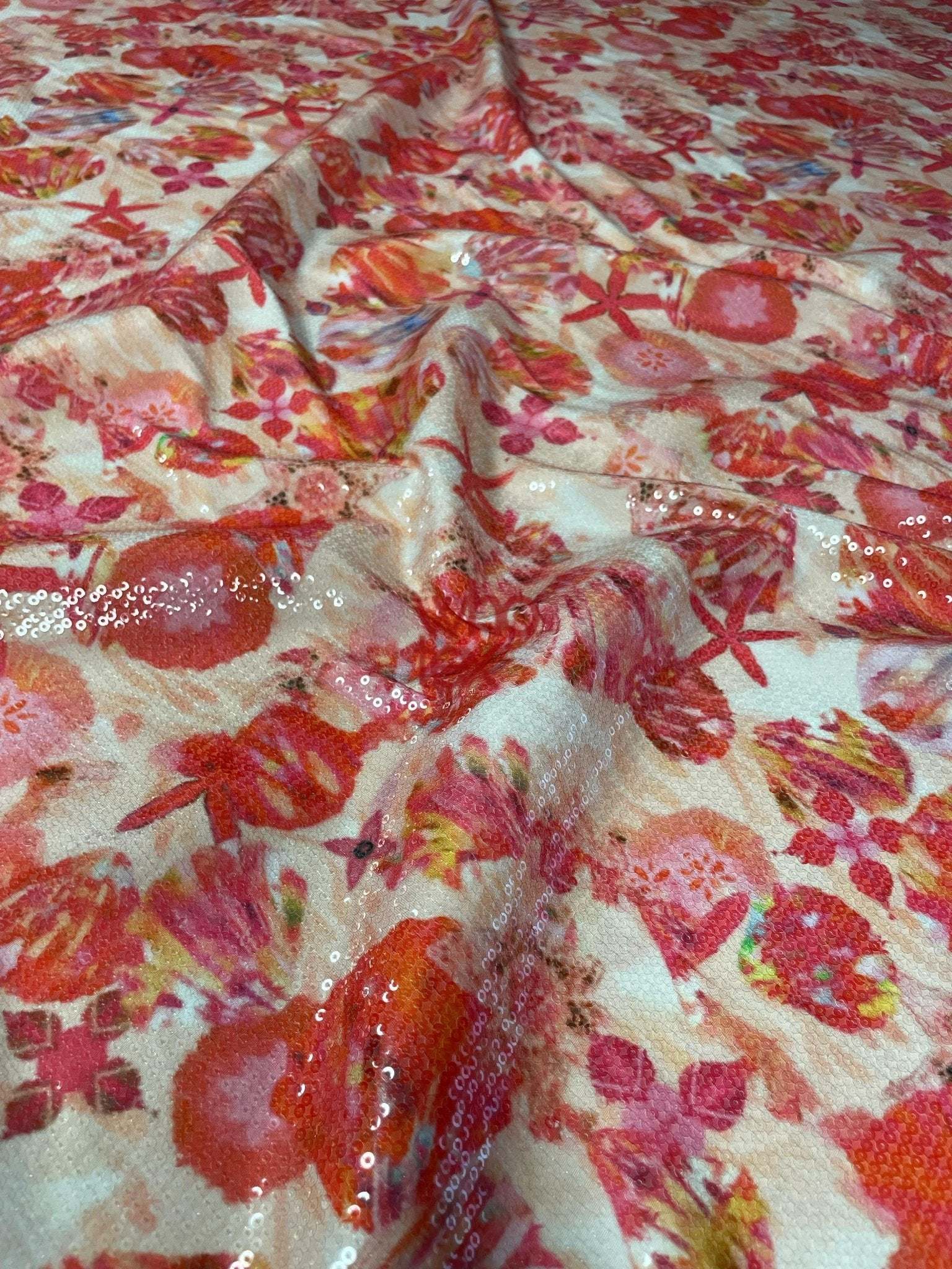 Floral sequin fabric with red and pink starfish design and 2-way stretch for fashion wear