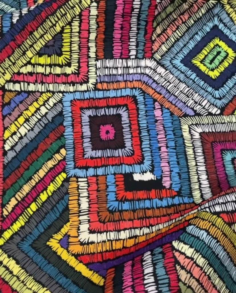 Close-up of vibrant geometric colorful wave fabric with overlapping multicolored square and wave patterns, ideal for upholstery.