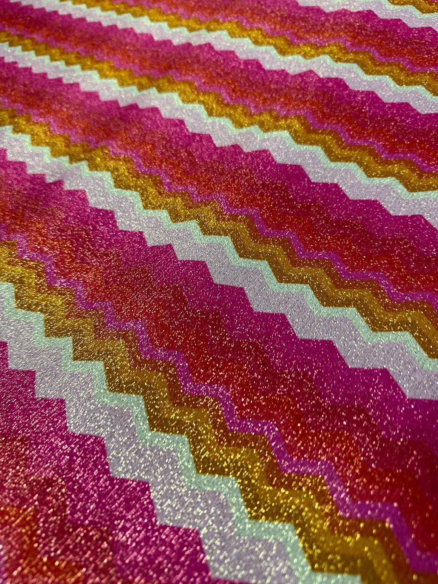 Gold Lurex pink zigzag knit fabric with glittery stretch texture and vibrant gold and pink stripes