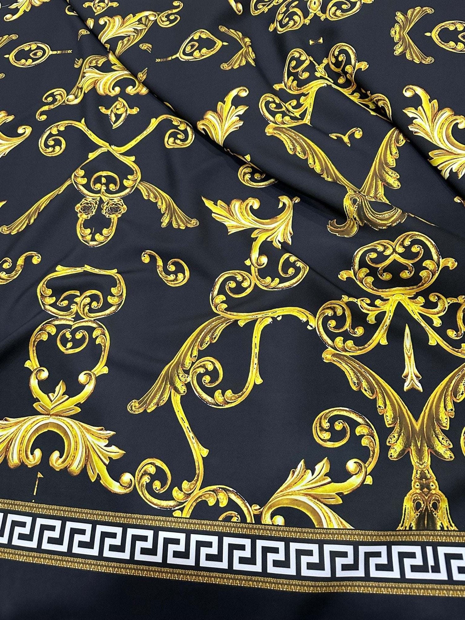 Black fabric with ornate gold Greek key and baroque pattern and white Greek key border design