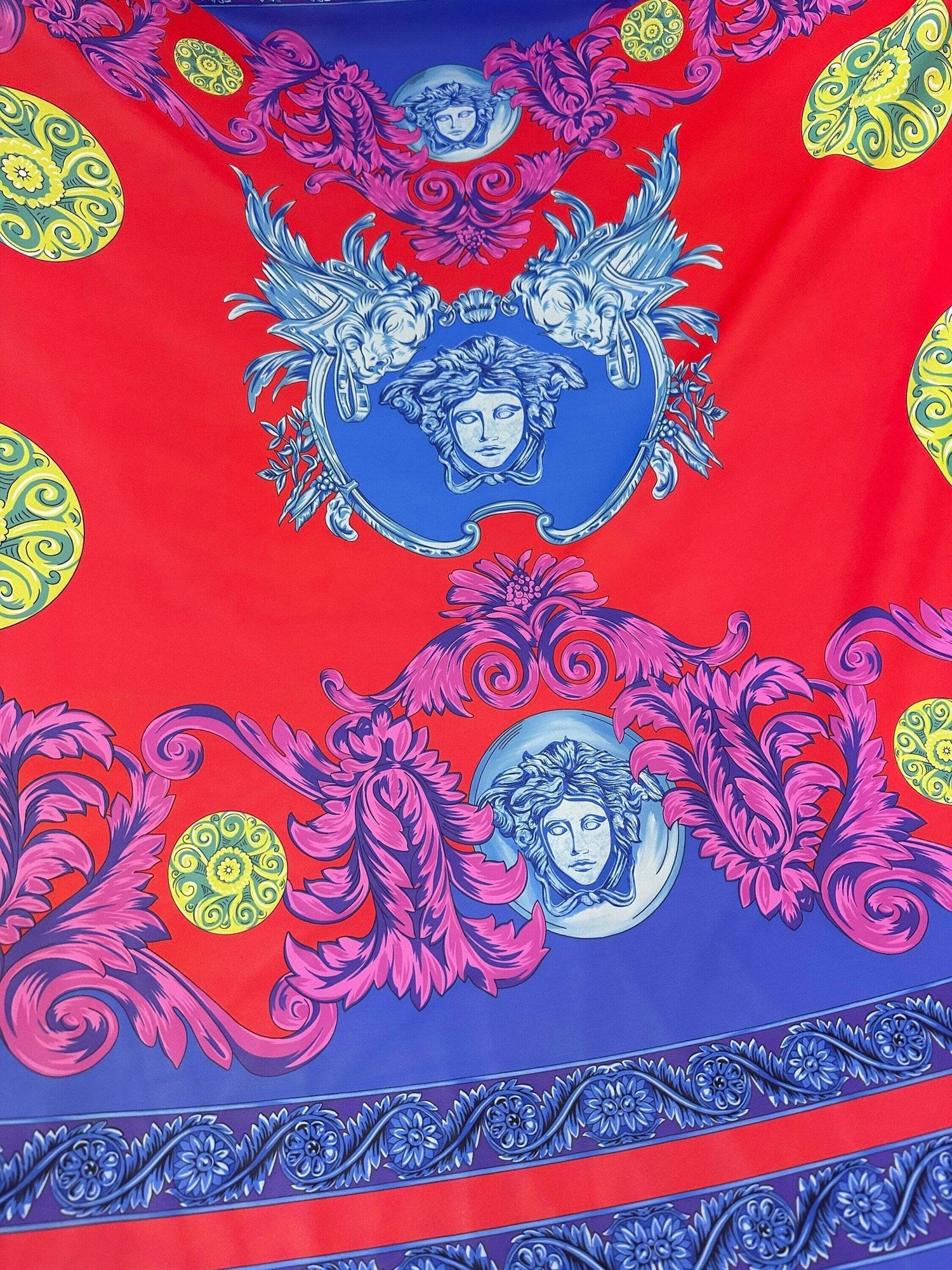 Purple swirl crepe fabric with blue and pink baroque design on red background and yellow decorative accents