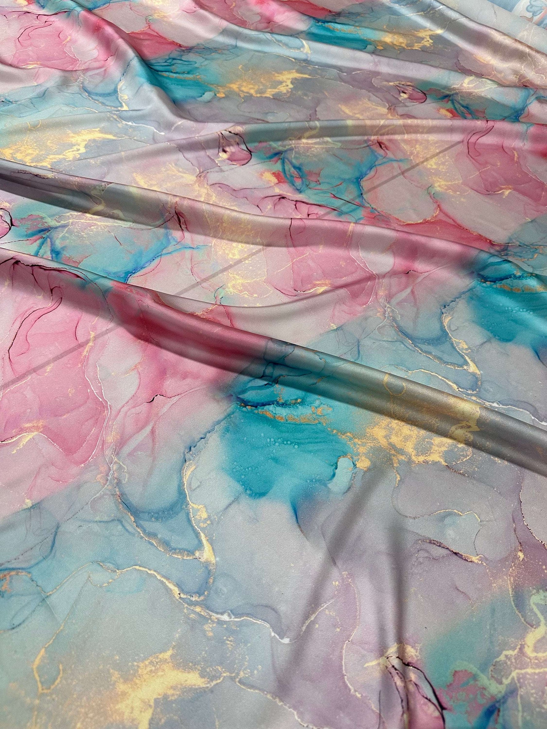 Soft and colorful Tie Dye Cloud Fabric by the Yard with vibrant pink, blue, and gold patterns, perfect for creative sewing projects