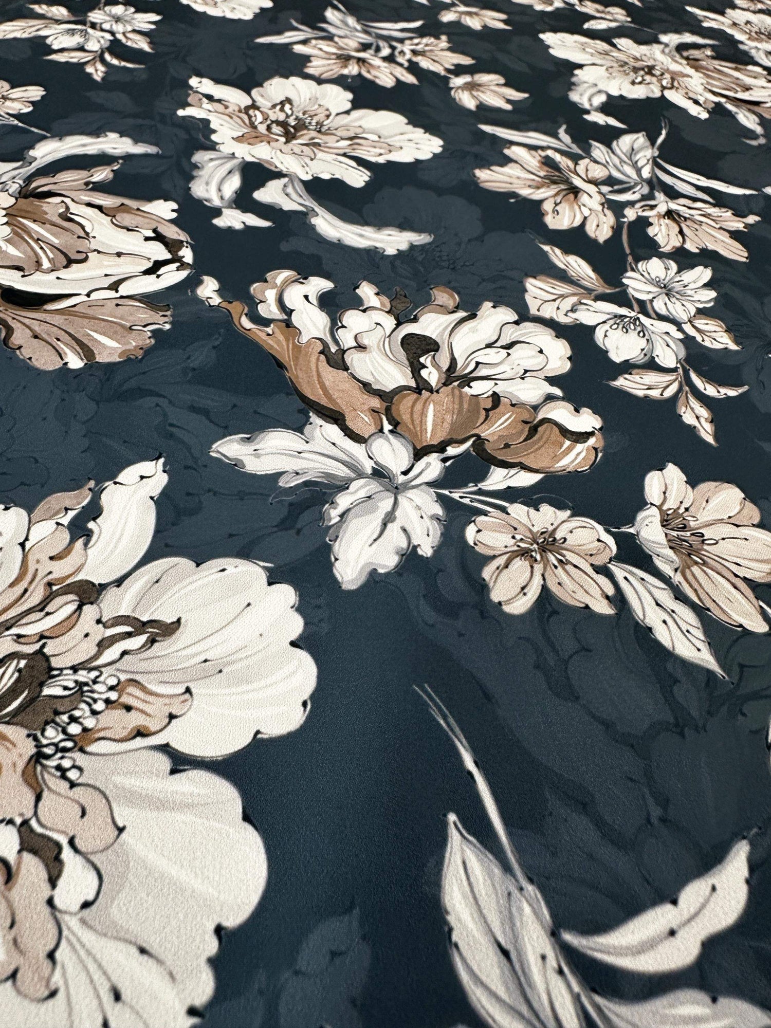 Close-up of vintage floral fabric with beige and white flowers on dark background