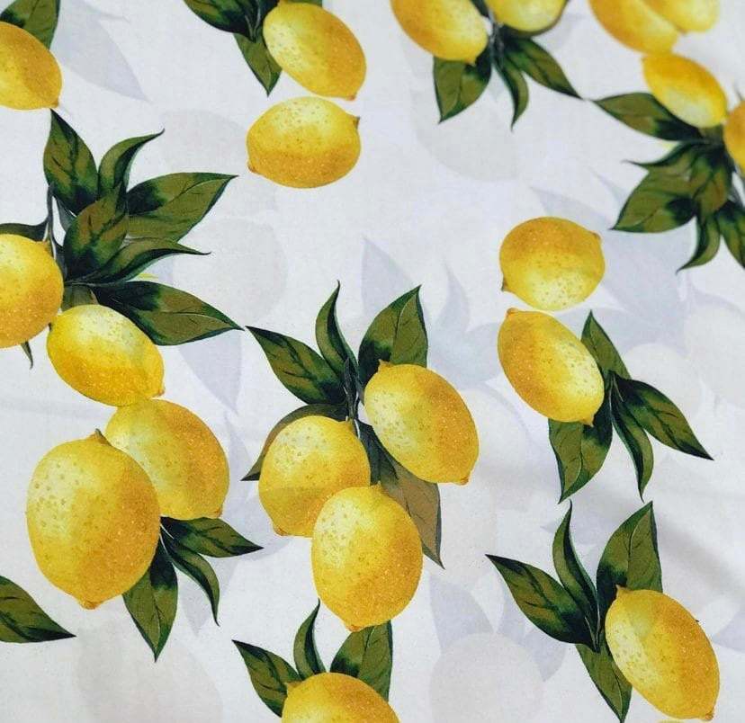 Yellow and white cotton fabric with vibrant lemon pattern and green leaves, 150cm wide