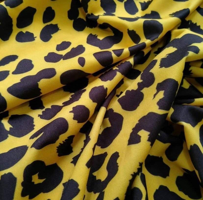 Yellow leopard pattern stretch fabric with black spots and soft texture