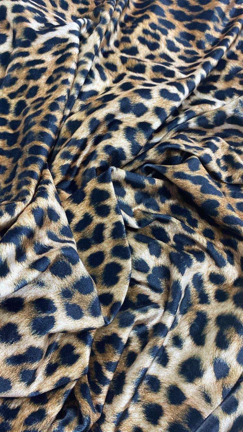 Leopard pattern stretch velvet fabric with soft, lightweight, wrinkle-free texture suitable for clothing and home decor.