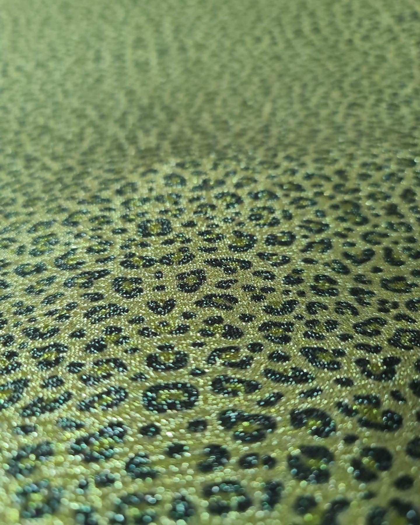 Close-up of shimmering leopard print Lurex fabric with stretch and silky satin finish suitable for activewear and costumes