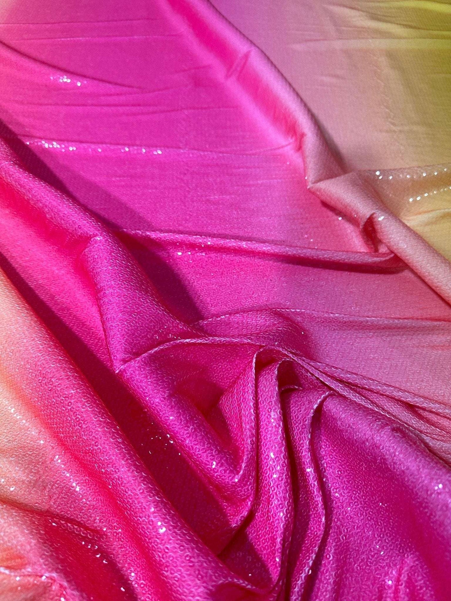 Ombre effect sequin fabric with a two-way stretch in pink to yellow gradient for evening wear.