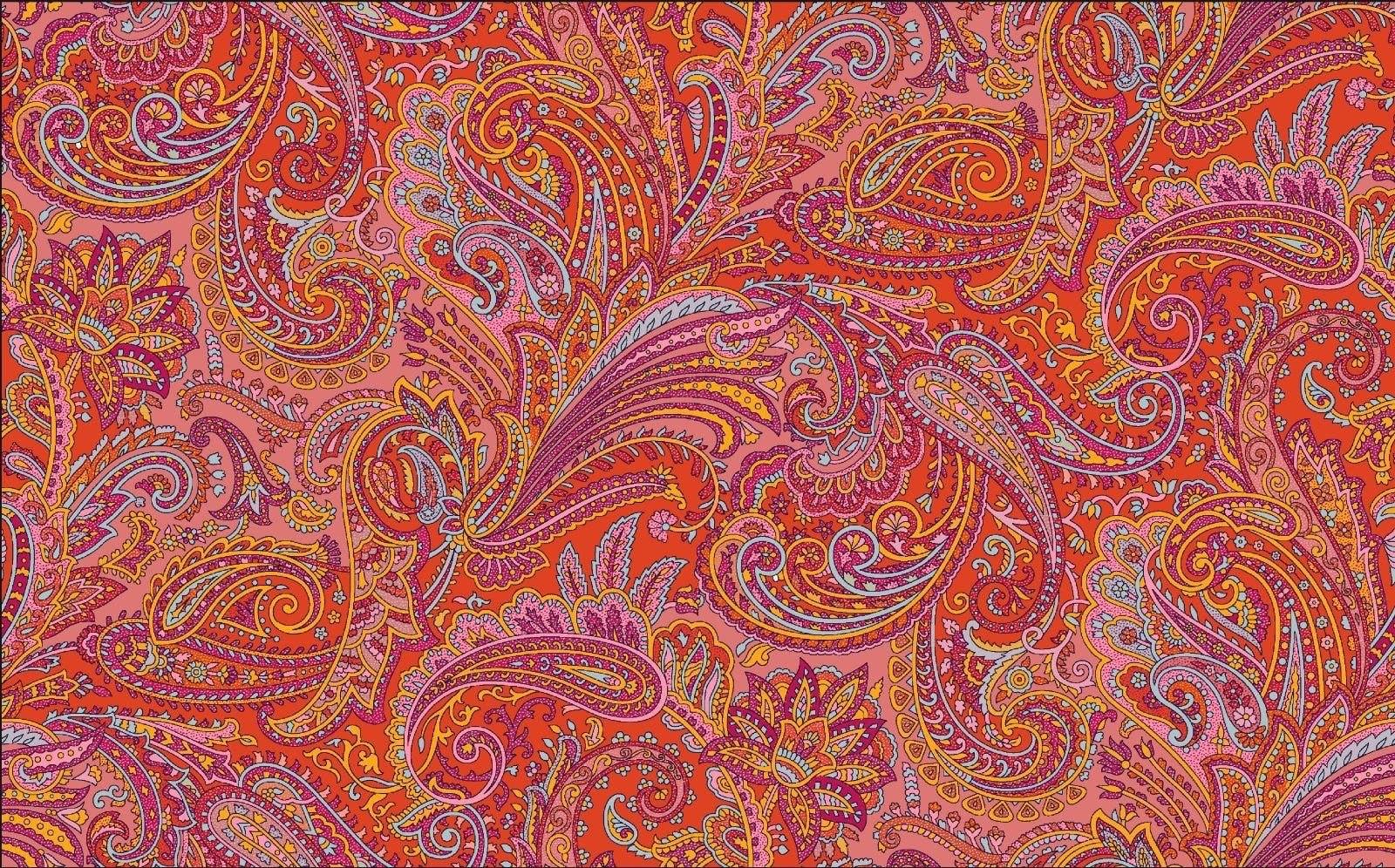 Bright orange paisley pattern fabric with intricate pink, purple, and yellow floral and swirl designs, ideal for sewing projects and quilting.