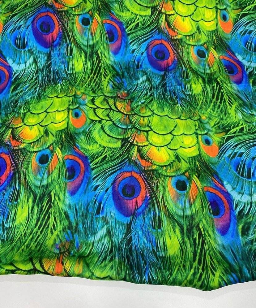 Vibrant green peacock feather fabric with blue and orange eye patterns, sold by the yard for sewing and upholstery projects.