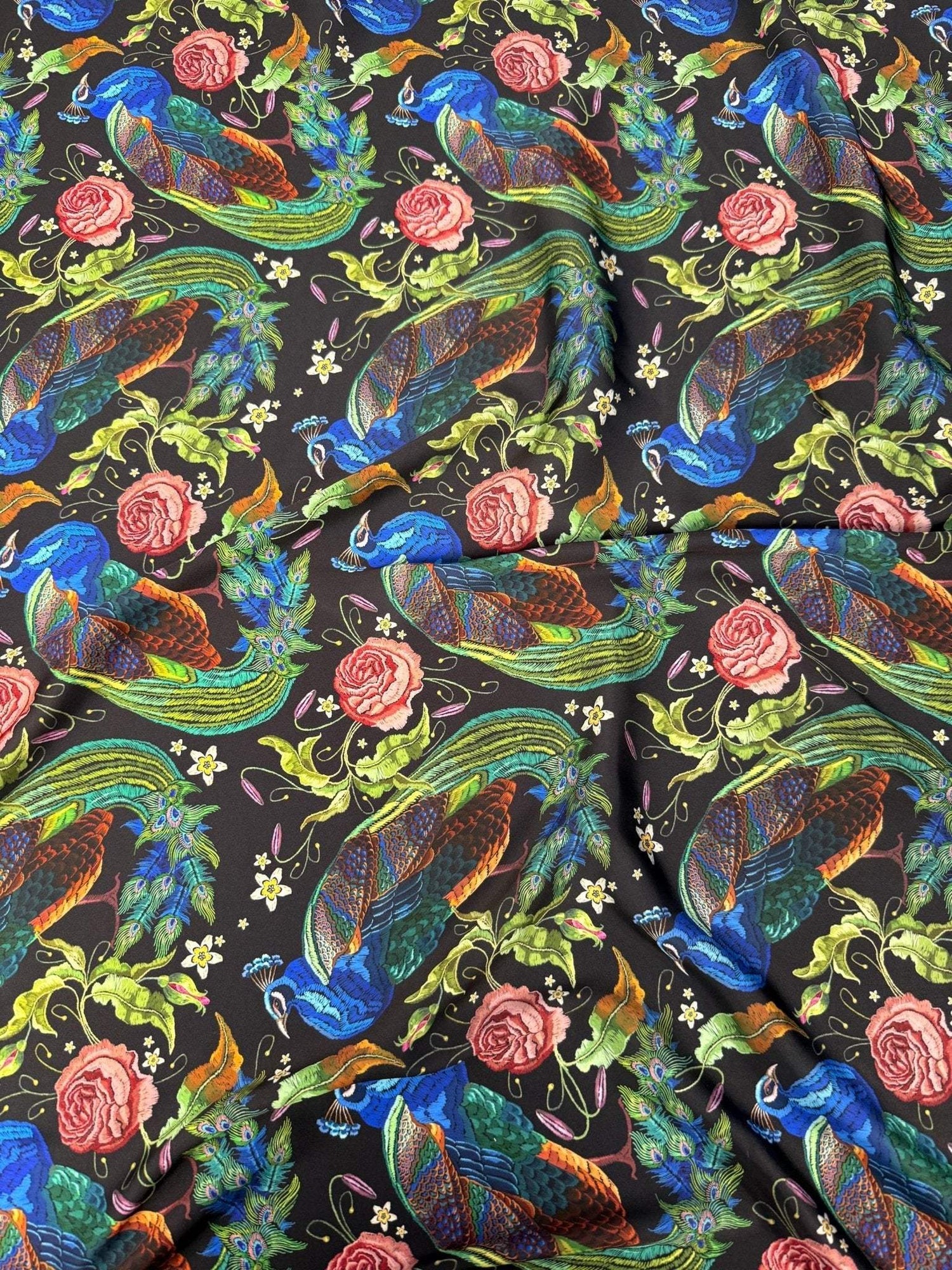 Peacock Rose Fabric with vibrant peacock and rose pattern on black cotton, ideal for sewing and home décor projects