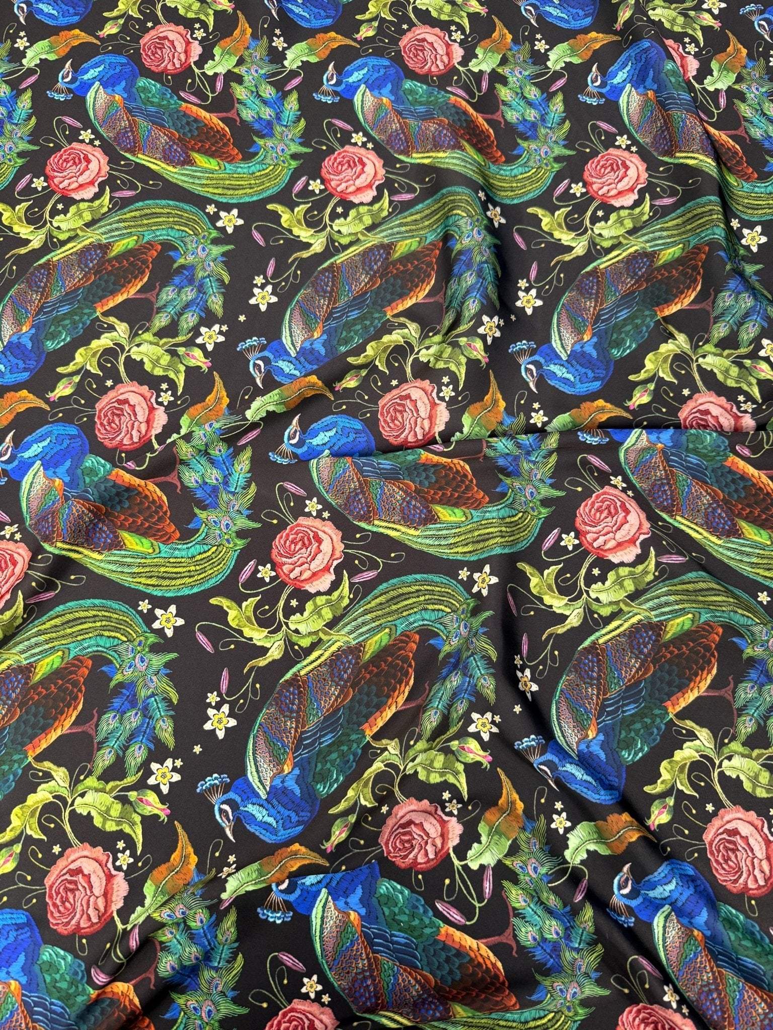 Peacock Rose Fabric with vibrant peacock and rose pattern on black cotton, ideal for sewing and home décor projects