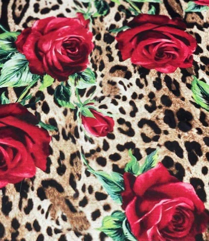 Leopard print fabric with vibrant red rose pattern and green leaves design