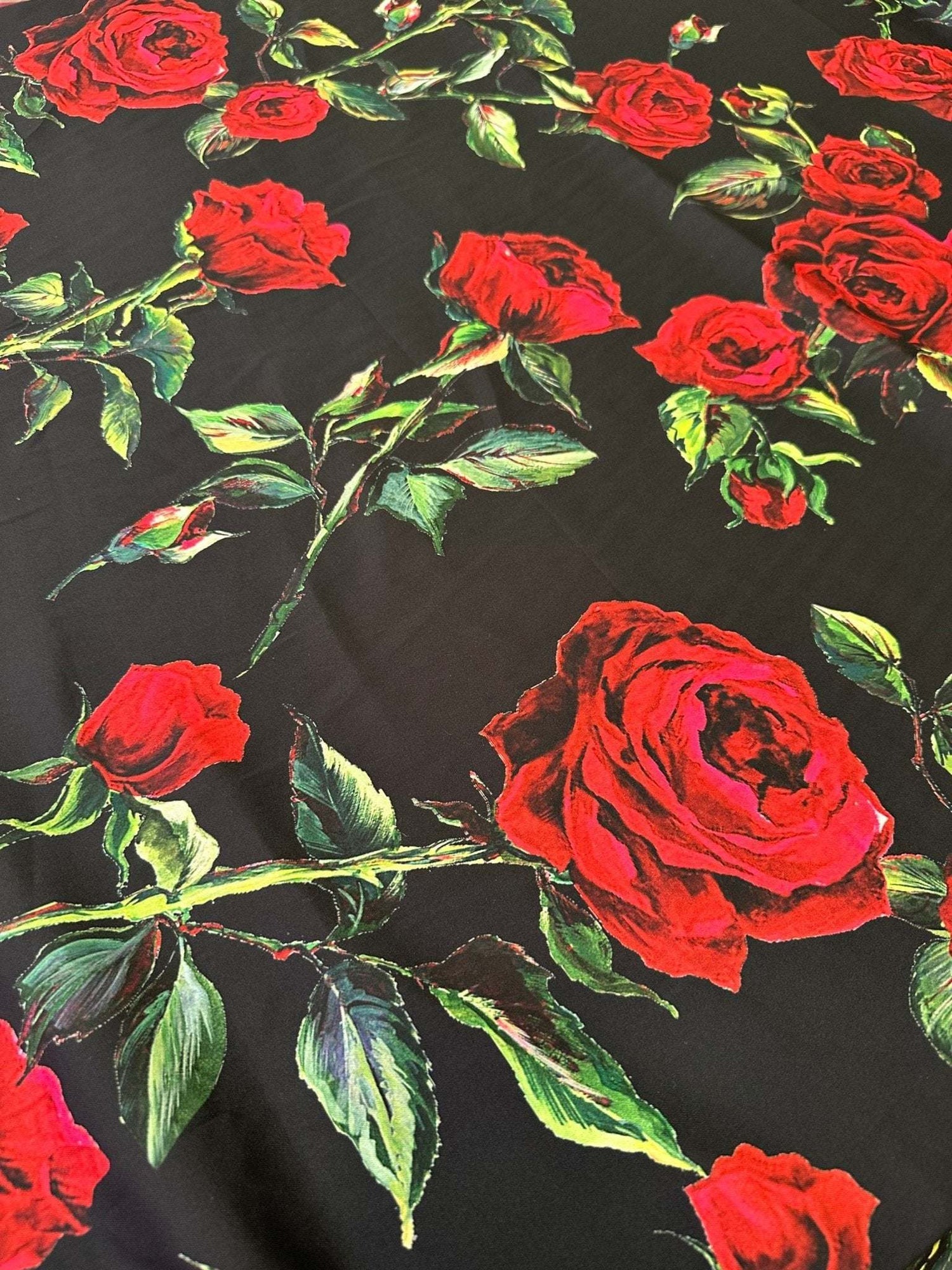 Black and red floral rose pattern fabric with green leaves on black background for sewing and crafts