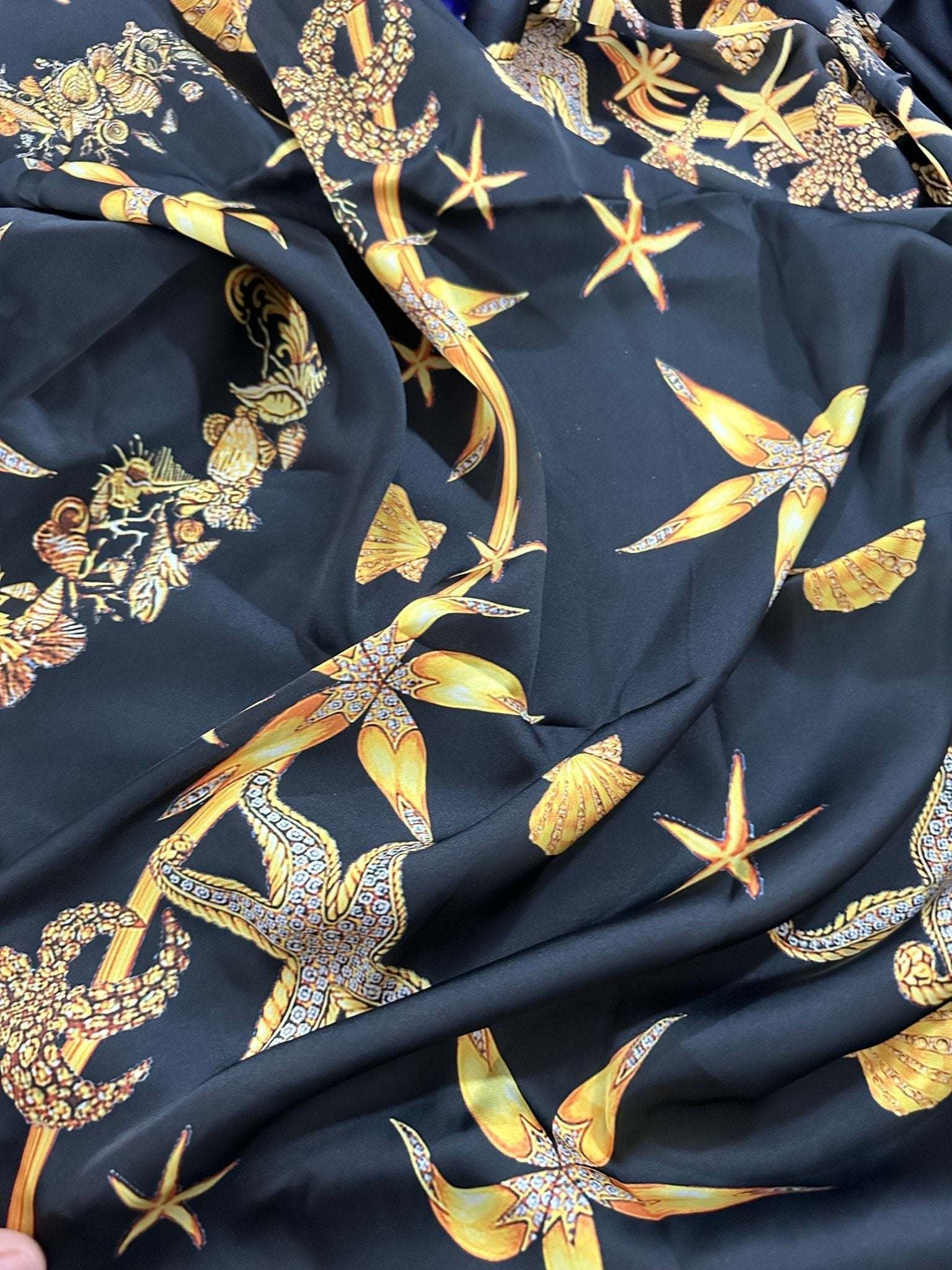 Black luxury fabric with gold sea shell and starfish pattern on black background