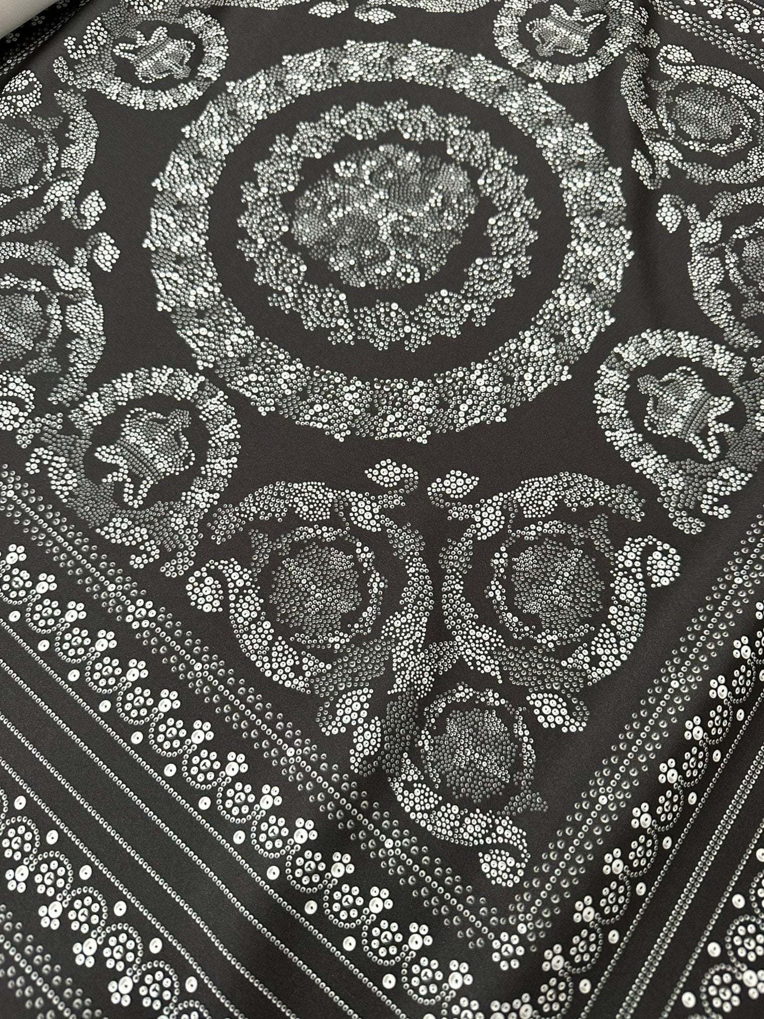 Baroque silver upholstery fabric with intricate floral and circular pattern on dark background