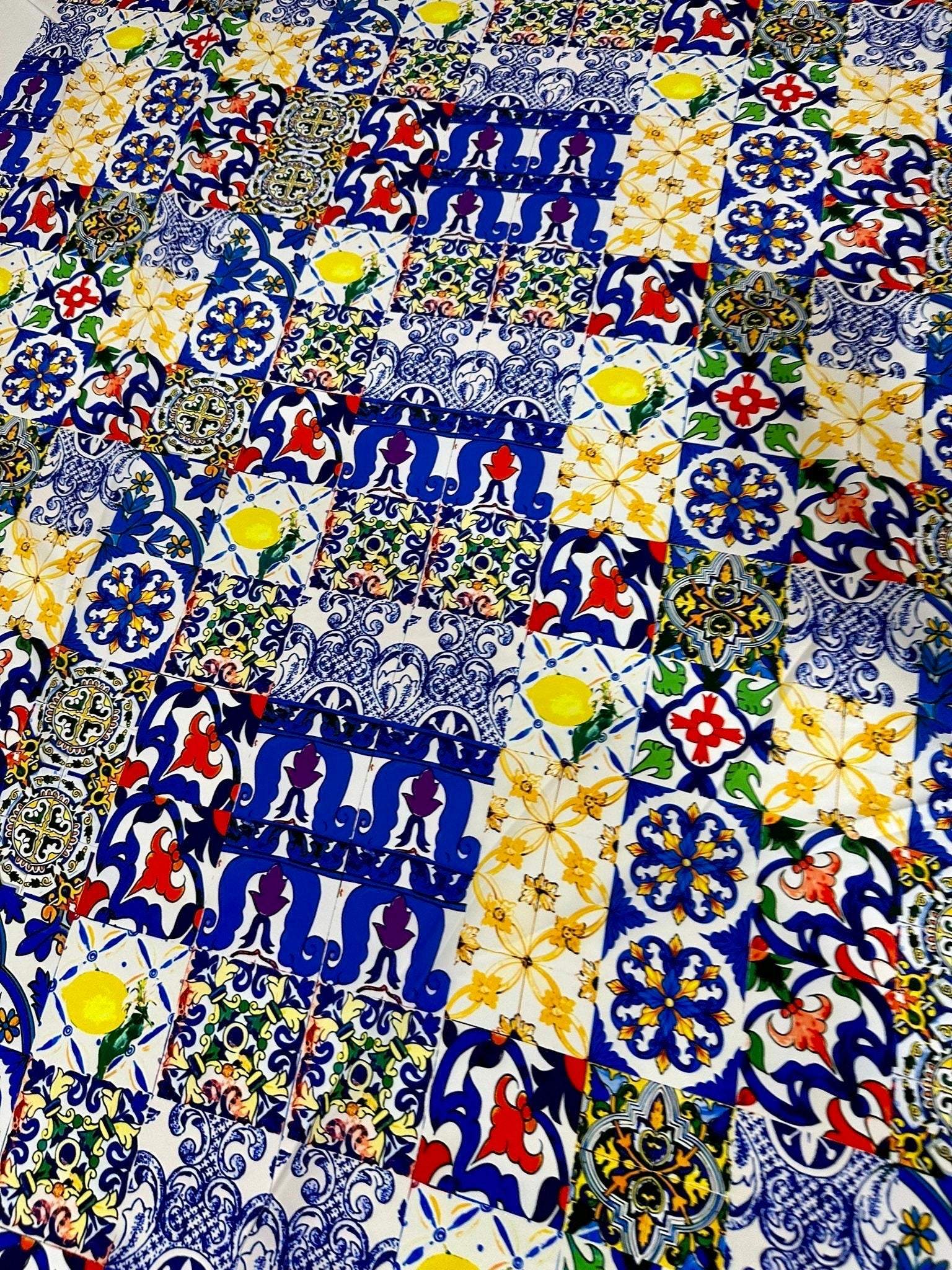 Colorful tile pattern fabric with blue, yellow, red, and green intricate designs, perfect for sewing and crafting projects