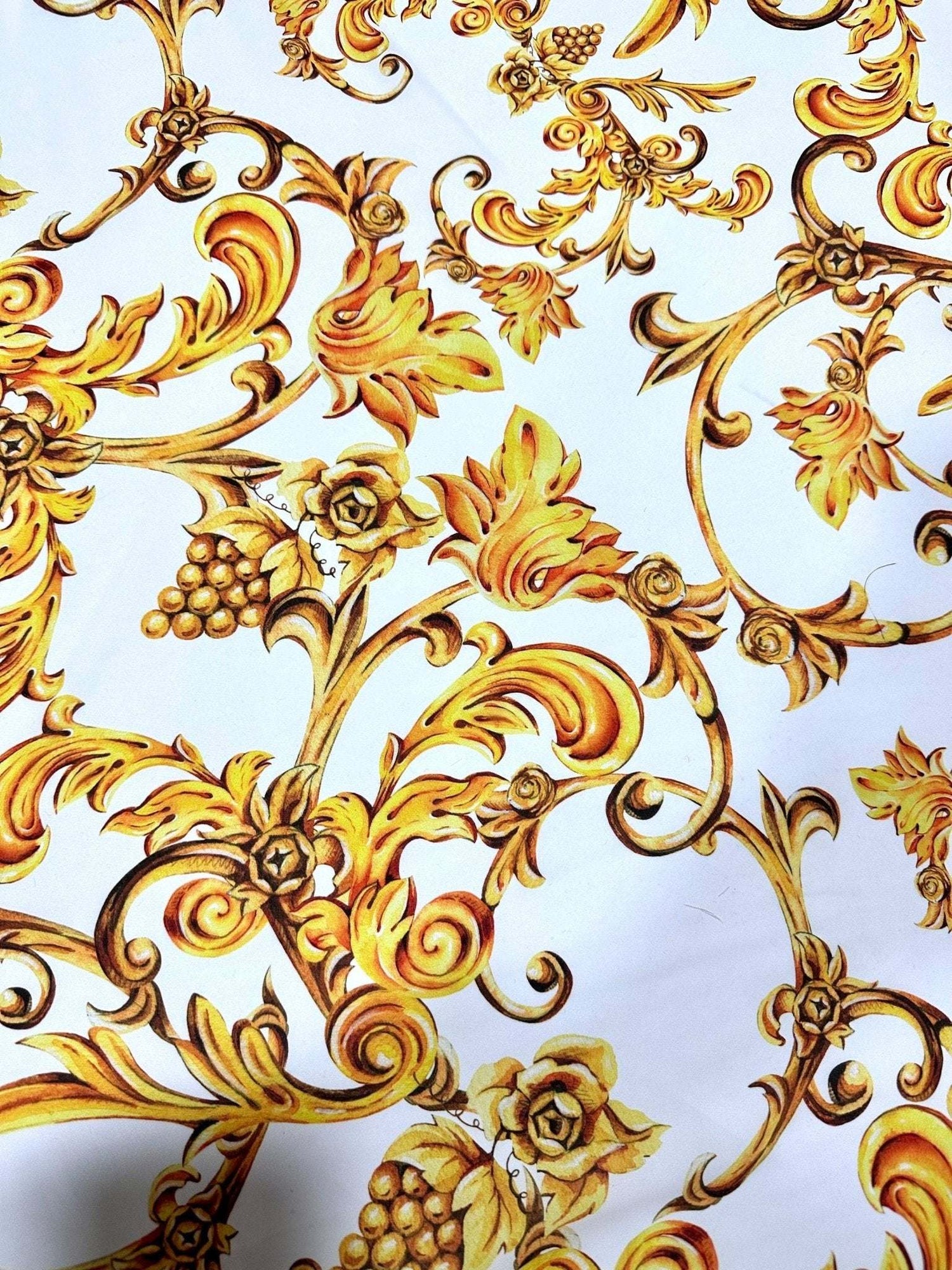 White fabric with ornate gold Baroque floral and scroll print design