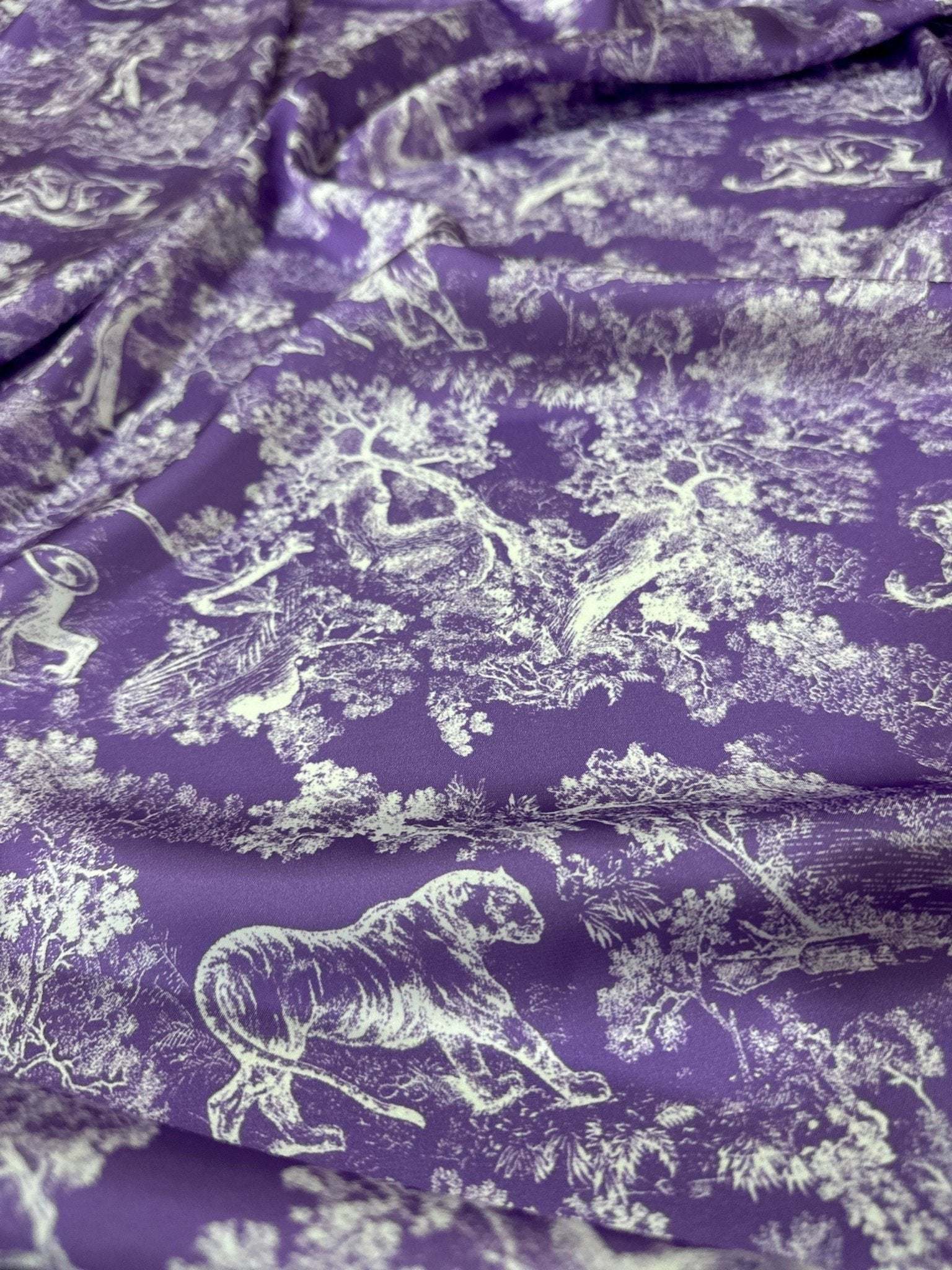 Purple fabric with white wild forest animal pattern for upholstery and crafts