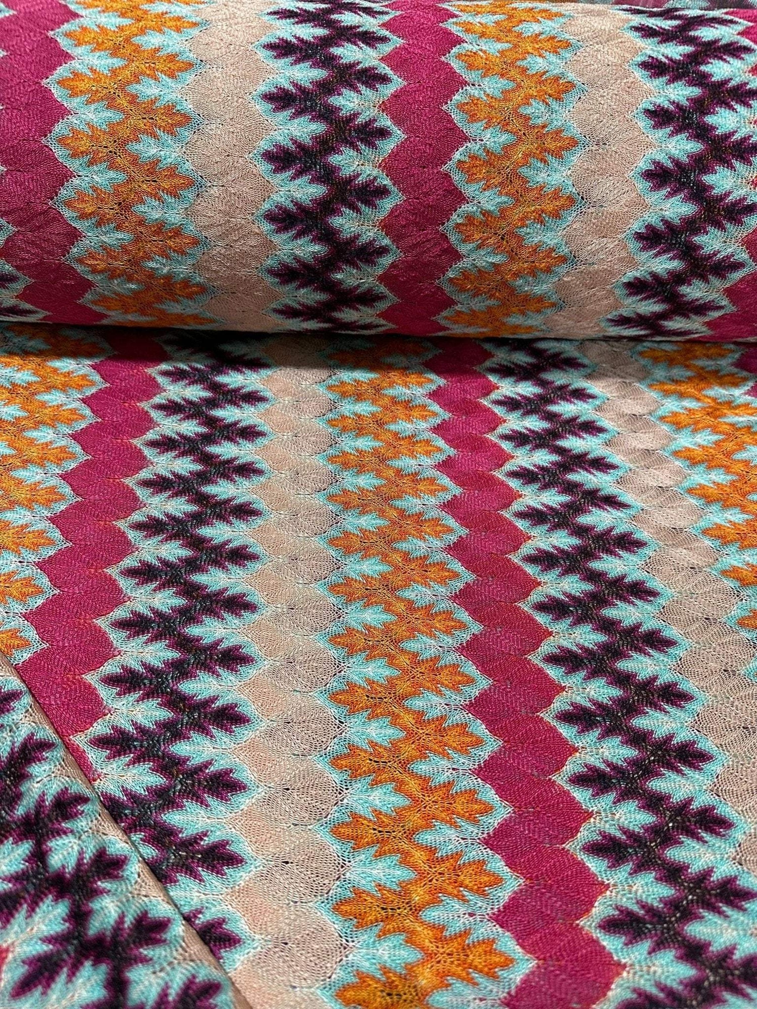 Zigzag Knit Jersey Fabric with multicolor chevron pattern in vibrant hues, soft and breathable knit textile ideal for sewing garments.