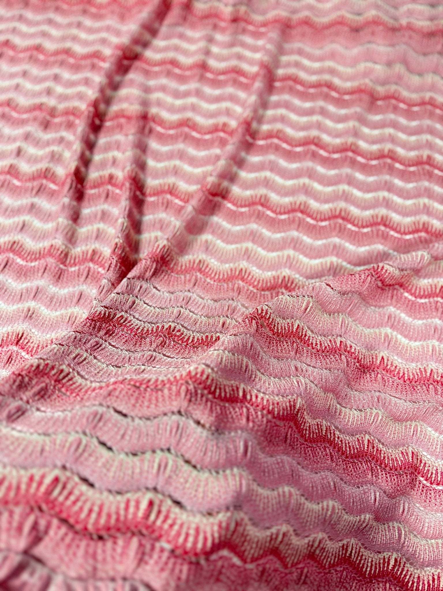 Pink tones zigzag mesh fabric with textured knit pattern ideal for elegant garments and sewing projects