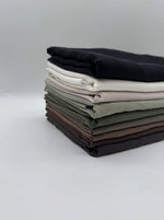 Modal Cupro Fabric by the Metre – Silk-Touch Floss Finish with Elegant Drape, showcasing a stack of various fabric colors.