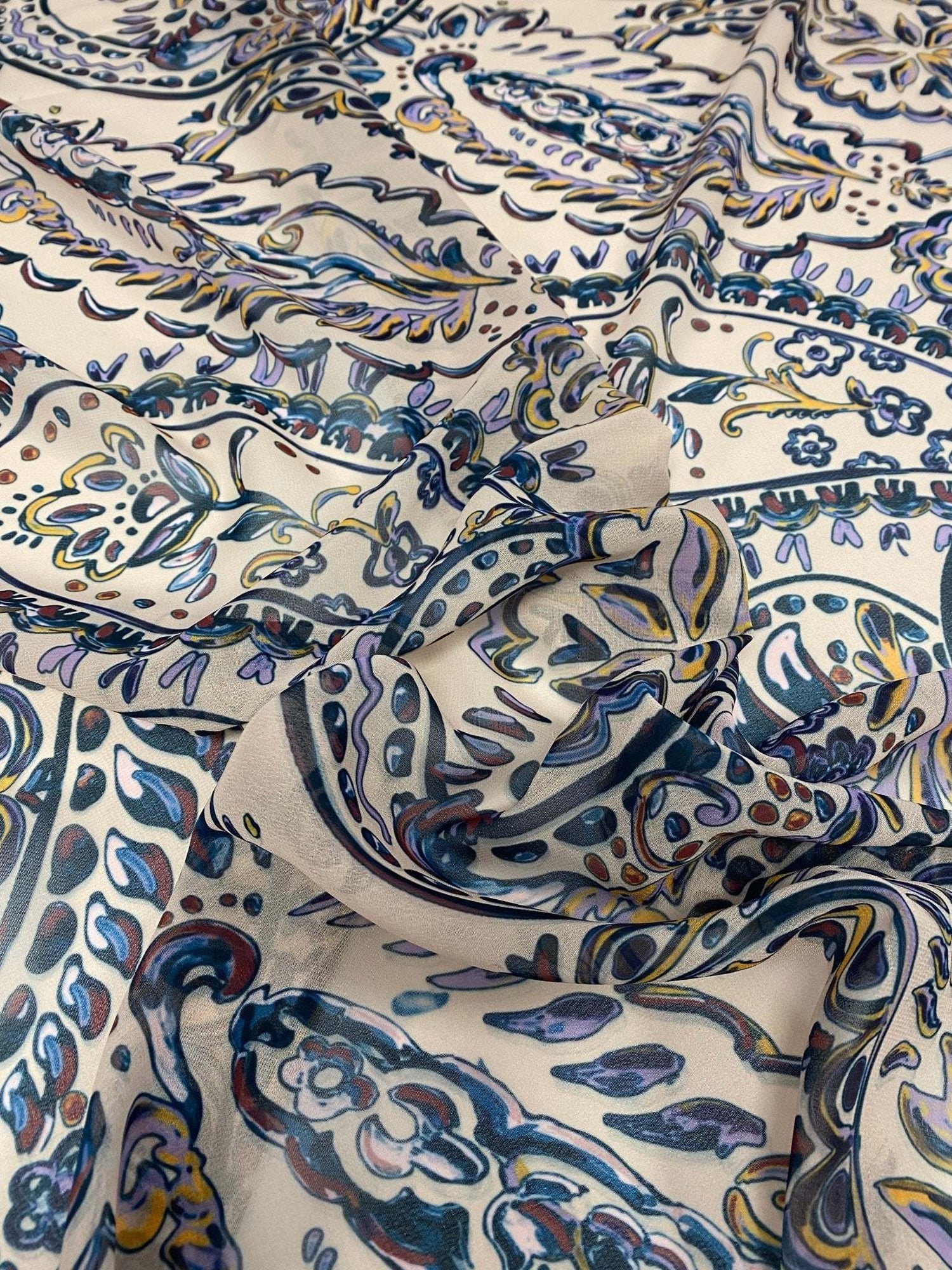 Cream background paisley print fabric with blue and gold intricate design details