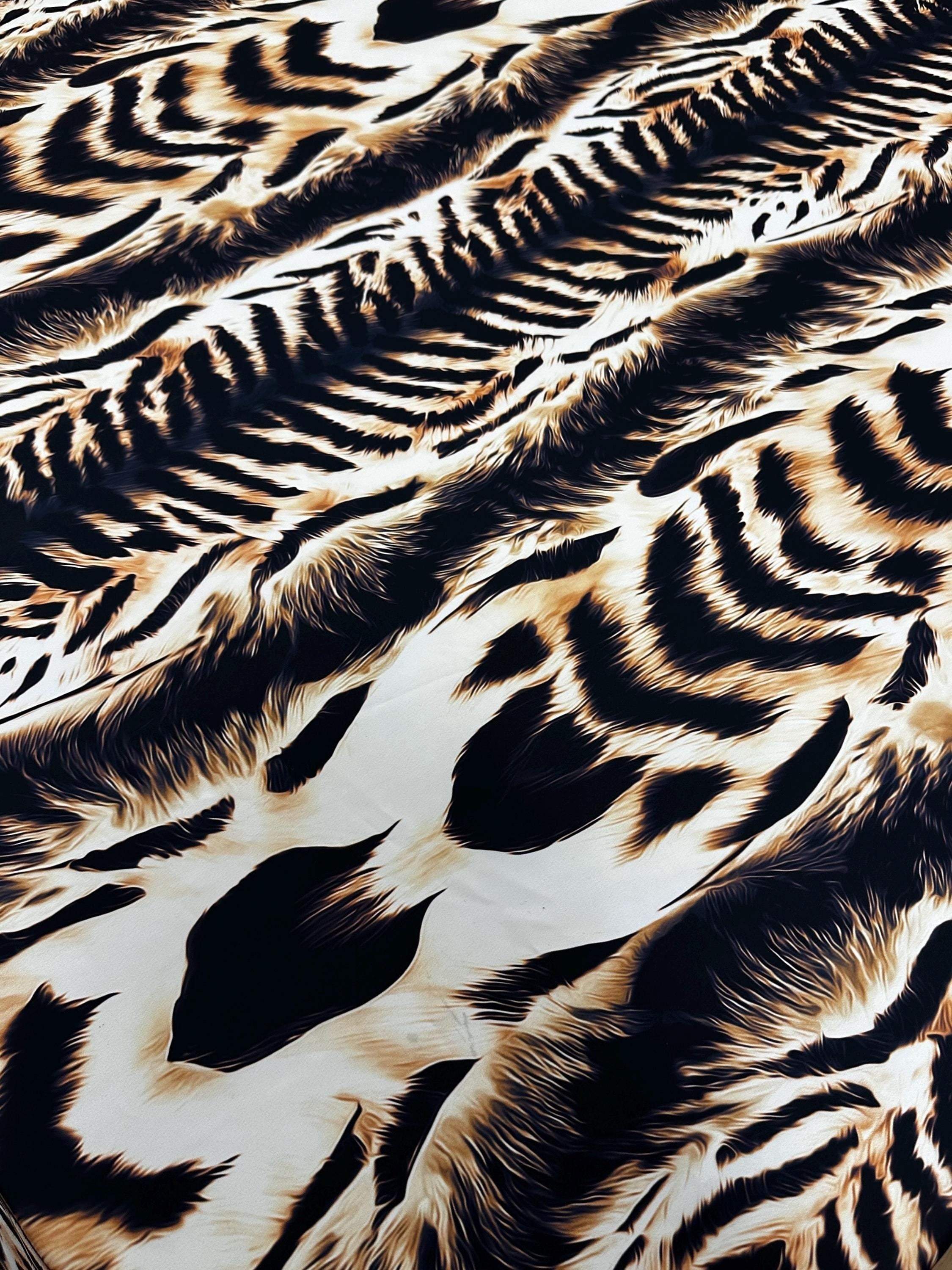 Close-up of high-quality animal print fabric with bold black, brown, and beige patterns ideal for sewing and crafts