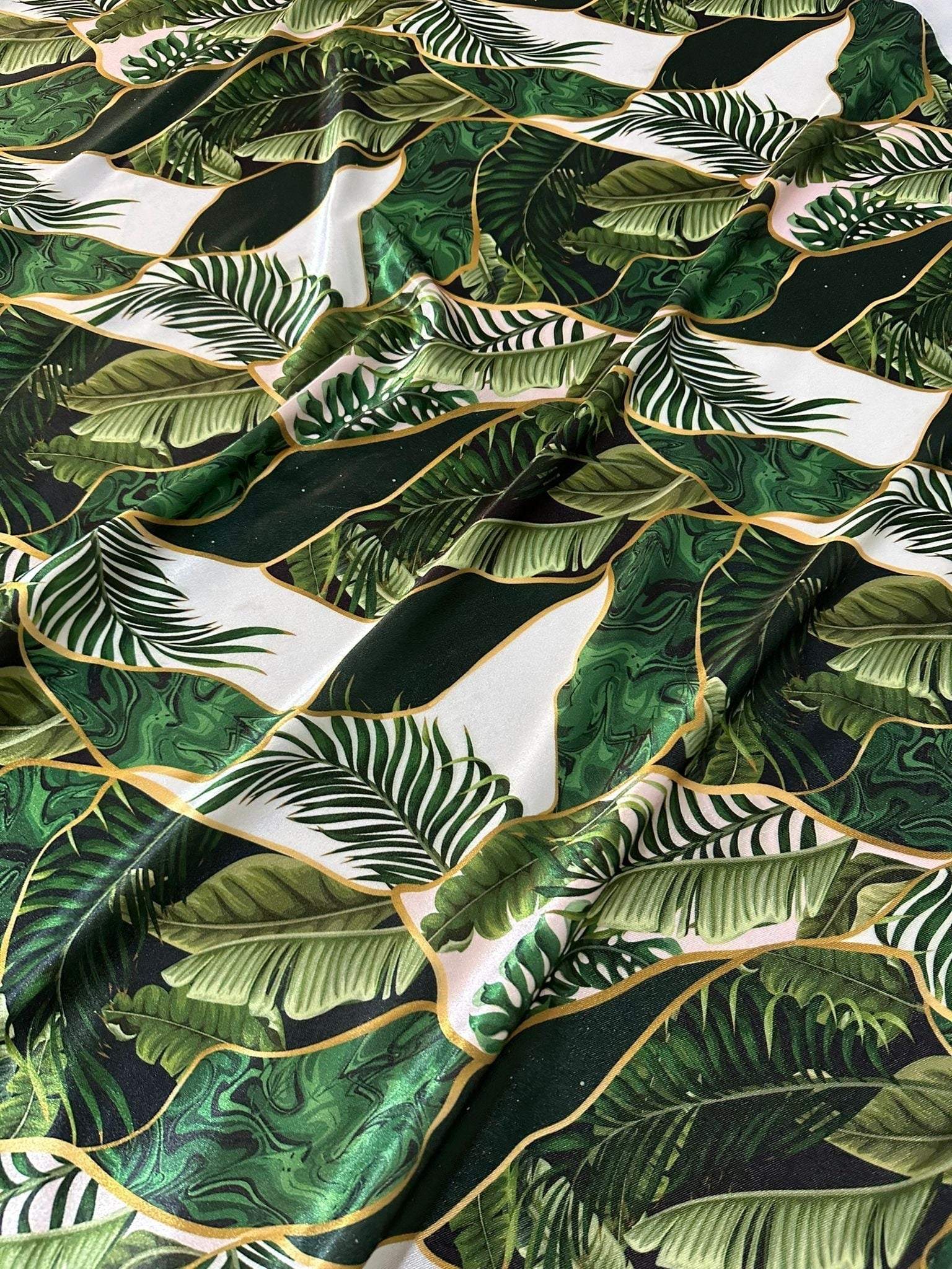 Leaf pattern stretch velvet fabric with green tropical leaves on white background, soft and stretchy velvet material