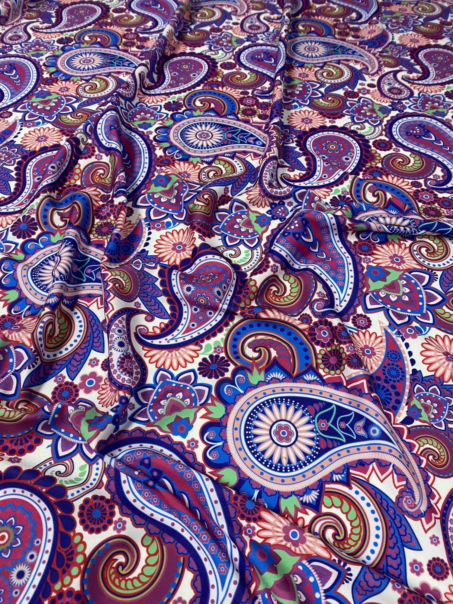 Purple paisley fabric with intricate multicolored digital print, ideal for upholstery and home decor projects.