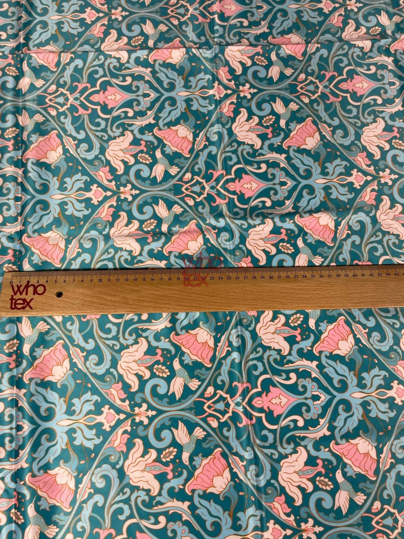 Vintage-inspired floral fabric with bird motifs in teal and pink tones, shown with a measuring ruler for scale