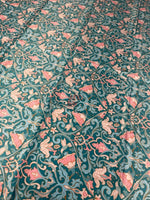 Vintage-inspired floral fabric with pink flowers and birds on teal background